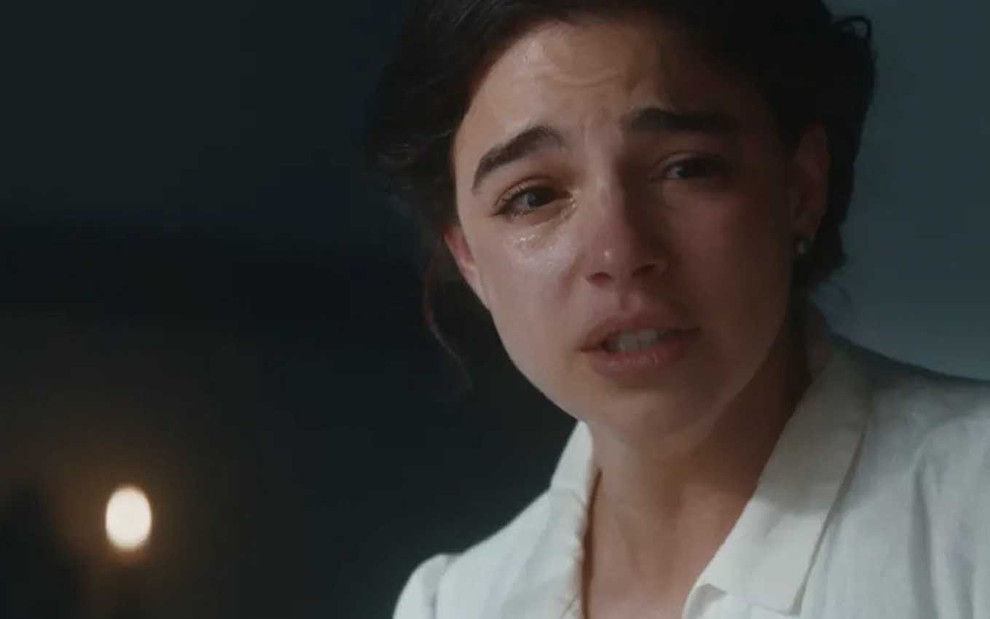 A atriz Gabriela Medvedovski como Pilar, vestida de médica, chora copiosamente em cena de Nos Tempos do Imperador