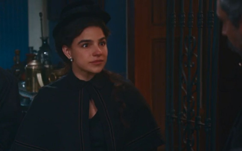 Pilar (Gabriela Medvedovski) está toda de preto na sala da casa de Tonico (Alexandre Nero) em cena de velório de Eudoro (José Dumont)