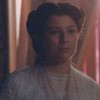Isabel (Giulia Gayoso) está pensativa em sala com cortina rosa ao fundo em cena de Nos Tempos do Imperador