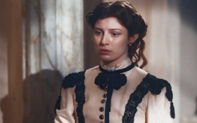 Atriz Giulia Gayoso olha para baixo com cara de preocupação em cena de Nos Tempos do Imperador