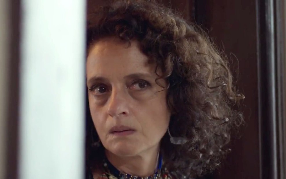 Denise Fraga em cena de Um Lugar ao Sol: atriz está em close e olha para alguém fora do quadro com lágrimas nos olhos