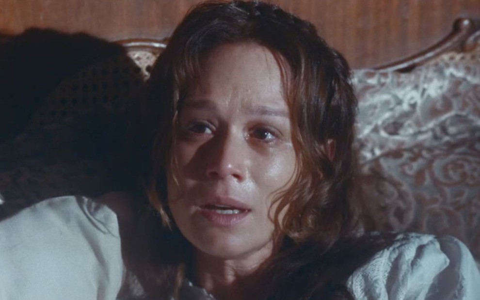 Mariana Ximenes em cena de Nos Tempo do Imperador: atriz está caracterizada como Luísa, com suor no rosto e deitada em cama