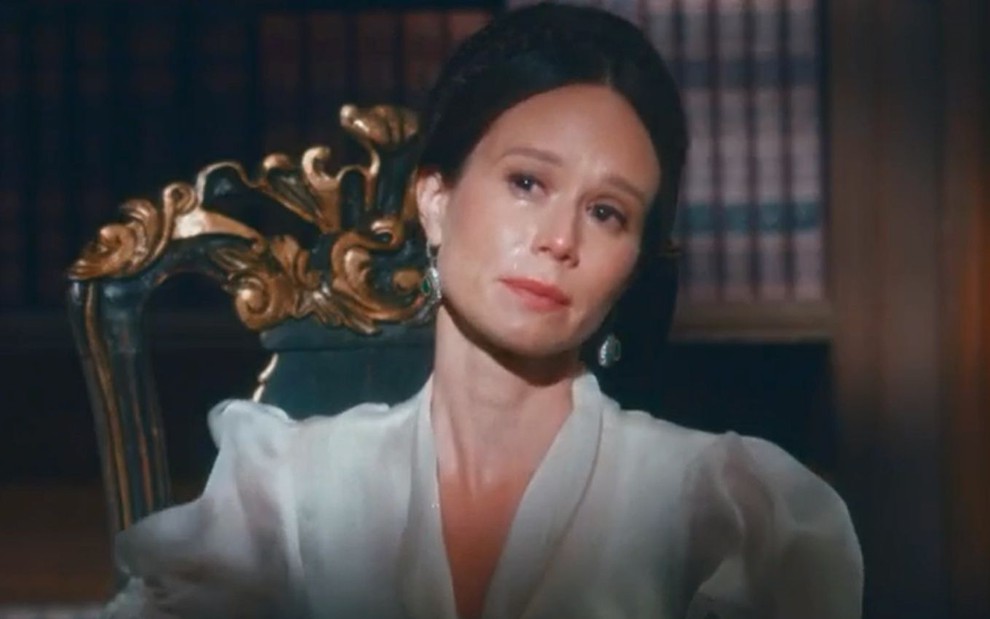 Luísa (Mariana Ximenes) chora sentada em uma poltrona na sala de estudos da Quinta da Boa Vista em cena de Nos Tempos do Imperador