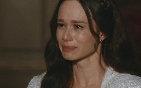 A atriz Mariana Ximenes está caracterizada como Luísa, com lágrimas nos olhos e expressão de tristeza, em cena de Nos Tempos do Imperador