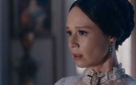 A atriz Mariana Ximenes como Luísa com expressão de tristeza em cena de Nos Tempos do Imperador