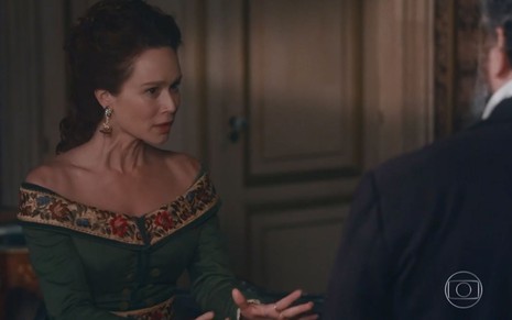 Luísa (Mariana Ximenes) está em pé, gesticula com a mão e conversa com Pedro (Selton Mello), que não aparece na foto, em cena de Nos Tempos do Imperador
