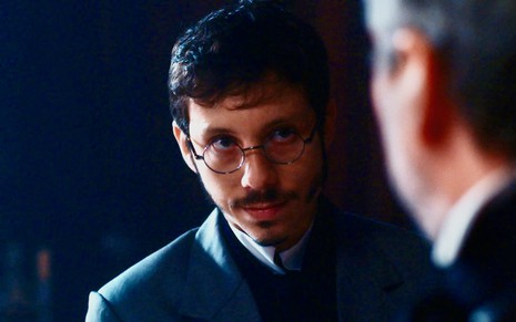 O ator João Pedro Zappa olha para Alexandre Nero com ar misterioso em gravação de cena de Nos Tempos do Imperador