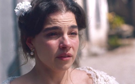 Gabriela Medvedovski caracterizada como Pilar em cena de Nos Tempos do Imperador: atriz está com arranjo branco na cabeça e chora