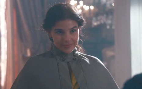 Gabriela Medvedovski em cena de Nos Tempos do Imperador: caracterizada como Pilar, atriz sorri para alguém fora do quadro