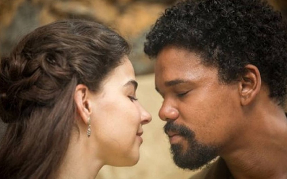 Gabriela Medvedovski, caracterizada como Pilar, e Michel Gomes, o Samuel, estão prestes a se beijar em cena de Nos Tempos do Imperador