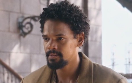 Michel Gomes em cena de Nos Tempos do Imperador: ator está caracterizado como Samuel e olha com seriedade para alguém fora do quadro