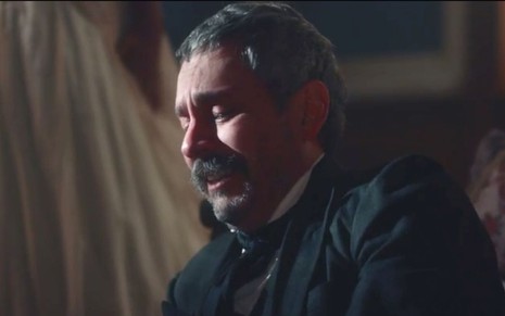 Alexandre Nero em cena de Nos Tempos do Imperador: ator está caracterizado como Tonico, sentado e chora