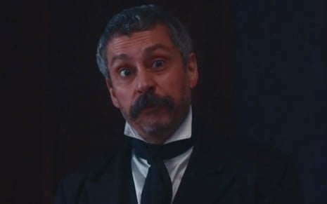 Alexandre Nero em cena de Nos Tempos do Imperador: ator está caracterizado como Tonico e tem olhar com indignação para alguém fora do quadro