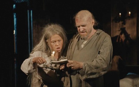 A atriz Vivianne Pasmanter como Germana segura uma vela e olha um envelope que está nas mãos de Guilherme Piva, o Licurgo, em cena de Nos Tempos do Imperador