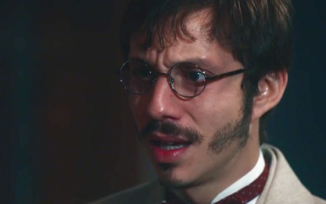 João Pedro Zappa em cena de Nos Tempos do Imperador: caracterizado como Nélio, ator está em close e chora para alguém fora do quadro