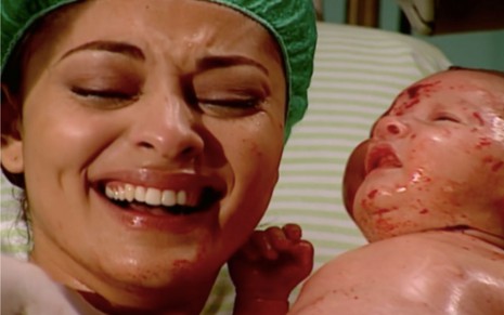 Juliana Paes em cena de O Clone: em close, a atriz está com touca cirúrgica e está do lado de bebê