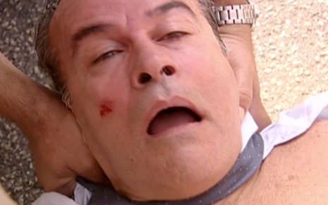 Osmar Prado em cena de O Clone: em close, ator usa camisa branca, está deitado com a boca aberta