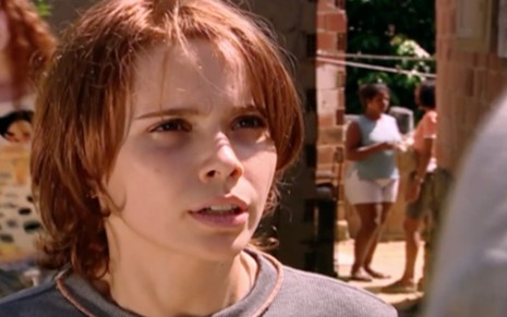 Débora Falabella em cena de O Clone: atriz usa blusa cinza, cabelos ruivos e olha para alguém fora do quadro