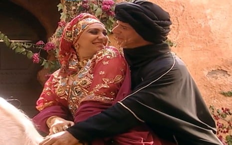 Eliane Giardini e Raul Gazolla em cena de O Clone: atores estão caracterizados como Nazira e Miro e em cima de cavalo