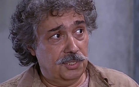 Pedro Paulo Rangel, caracterizado como Calixto, tem a expressão desconcertada em cena de O Cravo e a Rosa