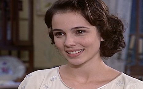 Miriam Freeland, caracterizada como Candoca, dá um sorriso doce em cena de O Cravo e a Rosa