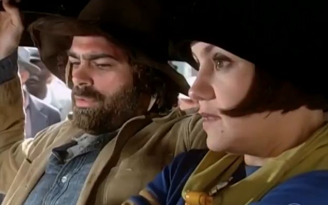 Eduardo Moscovis, caracterizado como Petruchio, encara Adriana Esteves, a Catarina, todo sorridente em cena de O Cravo e a Rosa