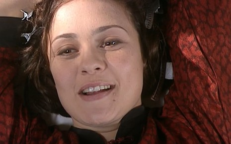 Adriana Esteves, caracterizada como Catarina, dá um sorriso sacana em cena de O Cravo e a Rosa
