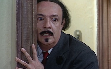 Ney Latorraca, caracterizado como Cornélio, tem o semblante cheio de ódio em cena de O Cravo e a Rosa; os dentes inferiores estão à mostra; os olhos, arregalados