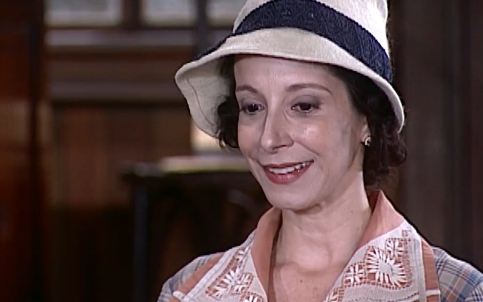 Bia Nunnes, caracterizada como Dalva, exibe sorriso esperançoso em cena da novela O Cravo e a Rosa