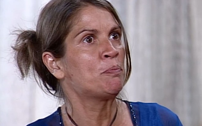 Tássia Camargo caracterizada como Joana: atriz não usa maquiagem e tem os cabelos presos. A boca está fechada, e os olhos, bem abertos, em cena de O Cravo e a Rosa