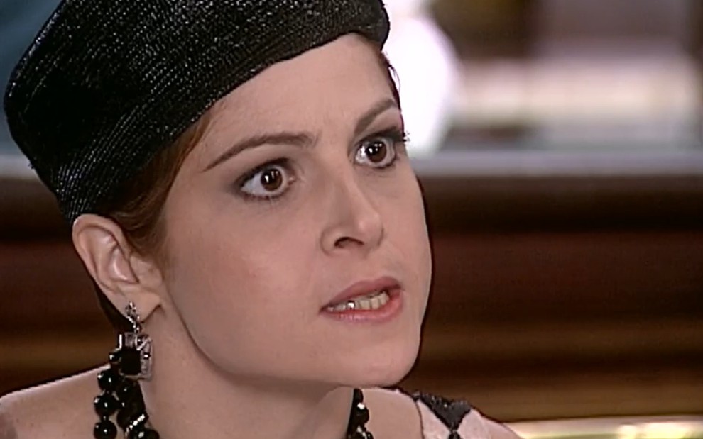 Drica Moraes, caracterizada como Marcela, tem os olhos arregalados e a boca semiaberta em cena de O Cravo e a Rosa