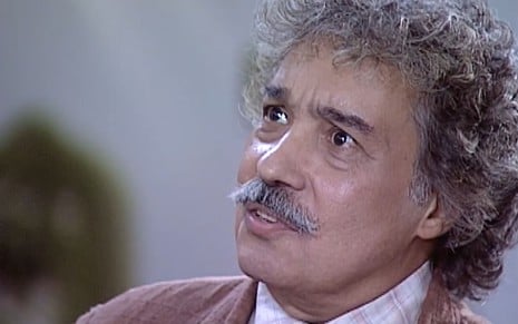 Pedro Paulo Rangel, caracterizado como Calixto, tem o semblante chocado em cena de O Cravo e a Rosa; ator usa terno surrado e bigode longo