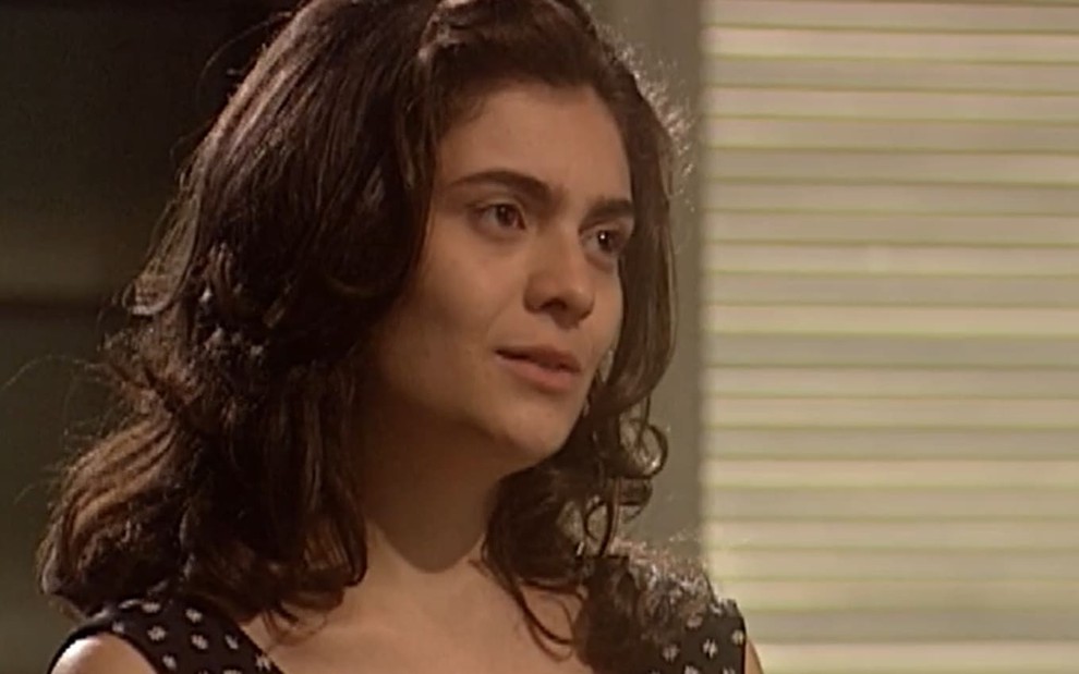 Arieta Corrêa em cena de O Rei do Gado; ela usa um vestido preto com poá branco; o semblante está sério