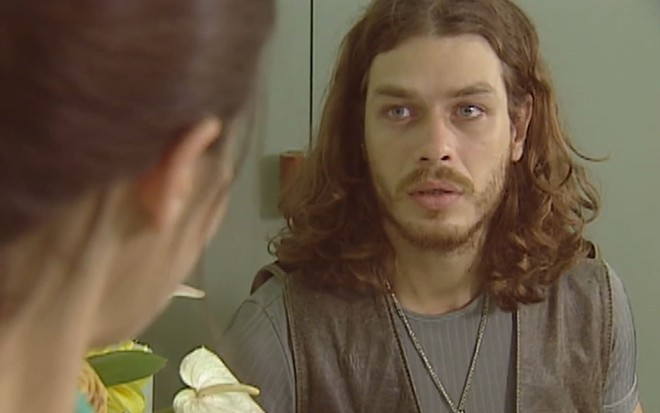 Fabio Assunção, caracterizado como Marcos, encara Mariana Lima --fora do quadro-- com um leve sorriso em cena de O Rei do Gado
