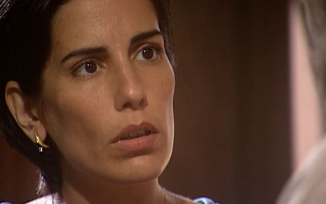 Gloria Pires caracterizada como Rafaela: ela tem o cabelo na altura do queixo e usa uma blusa branca; o semblante está chocado em cena de O Rei do Gado
