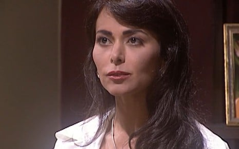 Leila Lopes caracterizada como Suzane em O Rei do Gado; ela dá um sorriso irônico em cena da novela