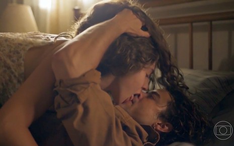 Juma (Alanis Guillen) e Jove (Jesuita Barbosa) se beijam na cama em cena de Pantanal, novela das nove da Globo