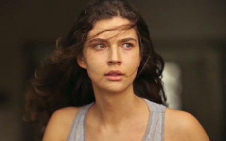 Alanis Guillen com expressão tensa, cabelo no rosto, como Juma na novela Pantanal