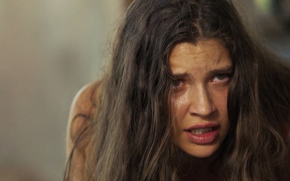 A atriz Alanis Guillen, engatinhando como uma onça, com expressão franzida como a Juma em cena de Pantanal