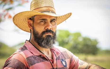 O ator Juliano Cazarré está caracterizado como o peão Alcides, com chapéu, barba grande e camisa desbotada, em locação da novela Pantanal