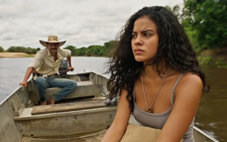 A atriz Bella Campos caracterizada como a Muda dentro de um barco a motor em cena de Pantanal