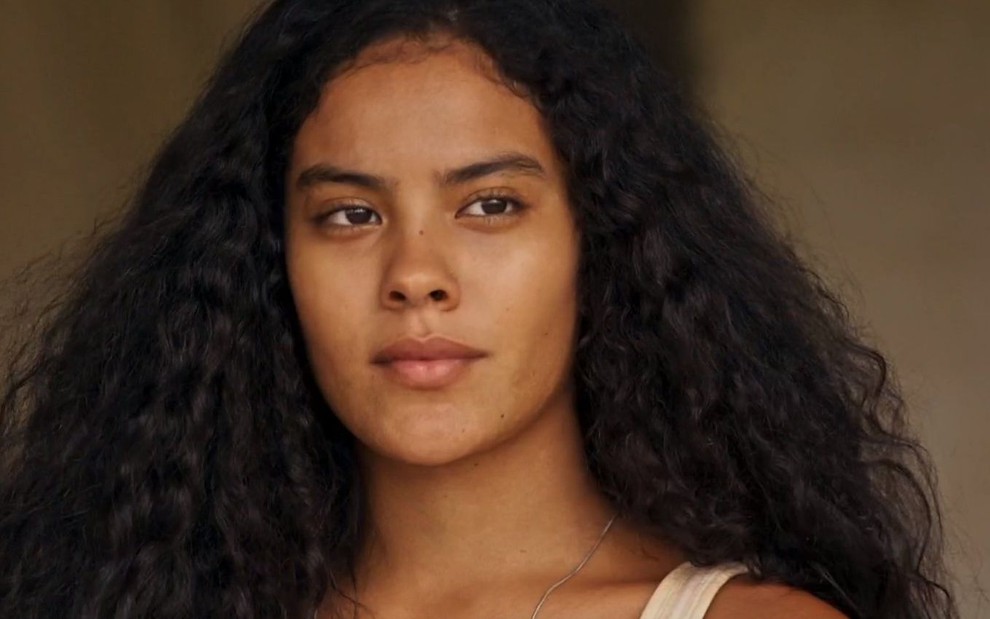 Muda (Bella Campos) está de cabelo solto e olha para frente em cena de Pantanal, novela das nove da Globo
