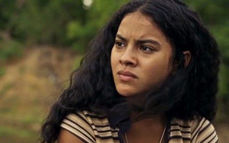 Muda (Bella Campos) está sentada em chalana em cena de Pantanal, novela das nove da Globo