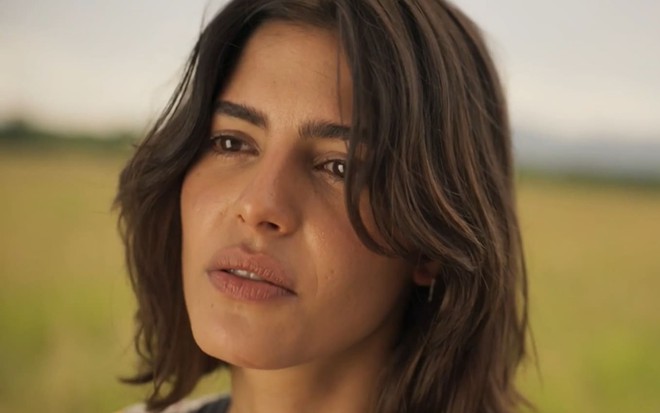Julia Dalavia, caracterizada como Guta, tem a expressão séria em cena de Pantanal
