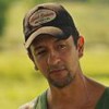 O ator Irandhir Santos aparece caracterizado como seu novo personagem em Pantanal, usando boné e com expressão séria