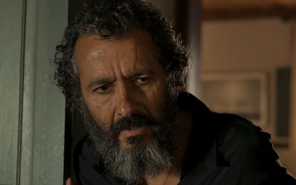 Marcos Palmeira caracterizado como José Leôncio: ator tem os cabelos e a barba longos e grisalhos; ele tem a expressão séria em cena de Pantanal