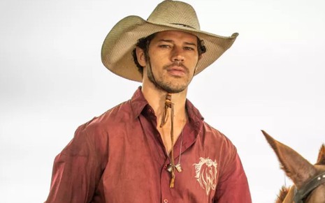 José Loreto grava cena com expressão séria, andando a cavalo, como Tadeu em Pantanal, novela das nove da Globo