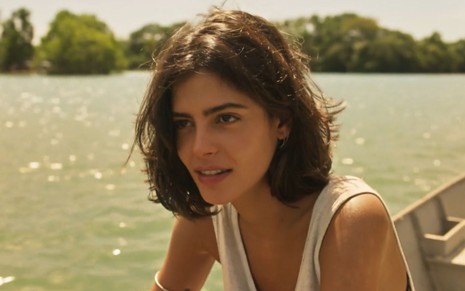 Julia Dalavia grava cena com expressão séria, como Guta de Pantanal