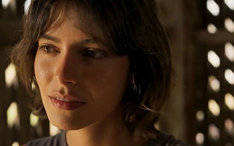 Guta (Julia Dalavia) está pensativa em cena de Pantanal, novela das nove da Globo