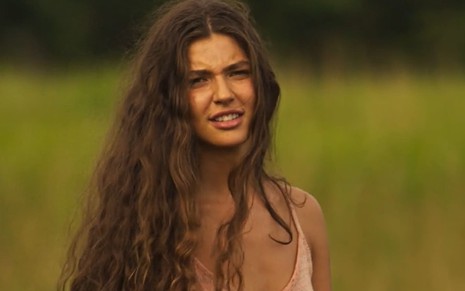 Alanis Guillen caracterizada como Juna; atriz tem a expressão confusa, com os olhos semicerrados, em cena de Pantanal